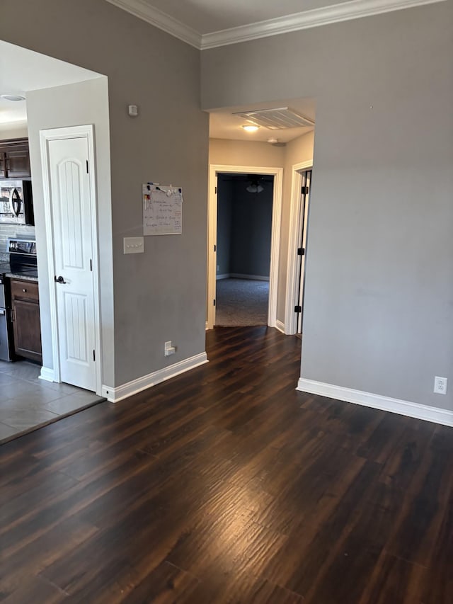 spare room featuring ornamental molding and dark hardwood / wood-style floors