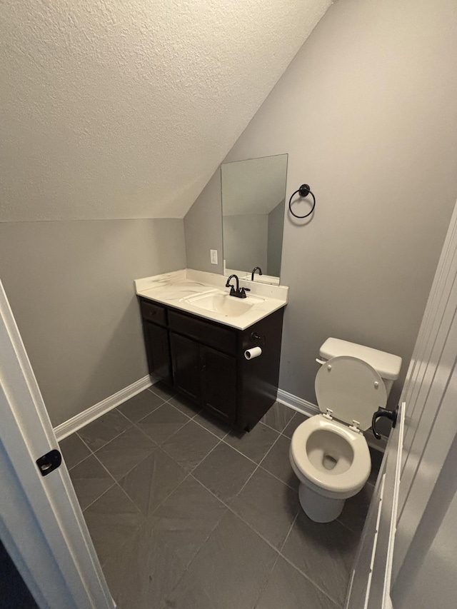 bathroom featuring toilet, a textured ceiling, tile patterned flooring, vanity, and vaulted ceiling