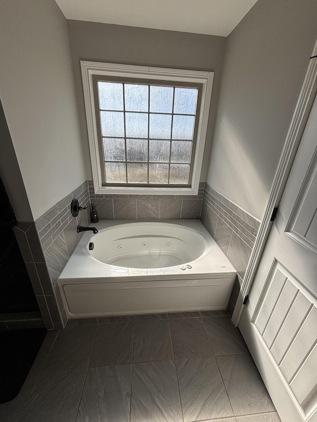 bathroom featuring a tub, tile patterned floors, and tile walls