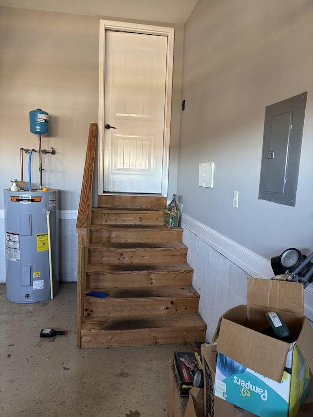 stairway featuring electric panel and electric water heater