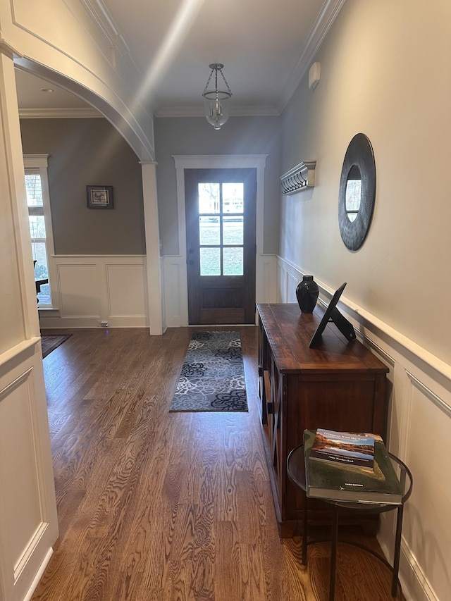 entryway with a healthy amount of sunlight, ornamental molding, and wood-type flooring