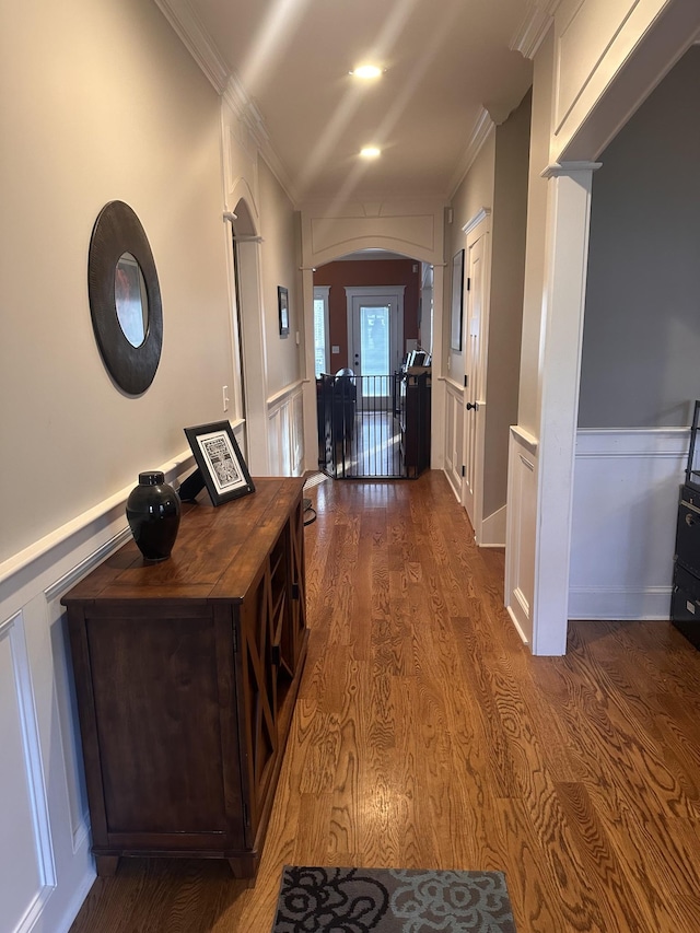 hallway with ornamental molding and dark wood-type flooring