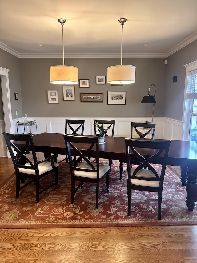 dining space with hardwood / wood-style floors and crown molding