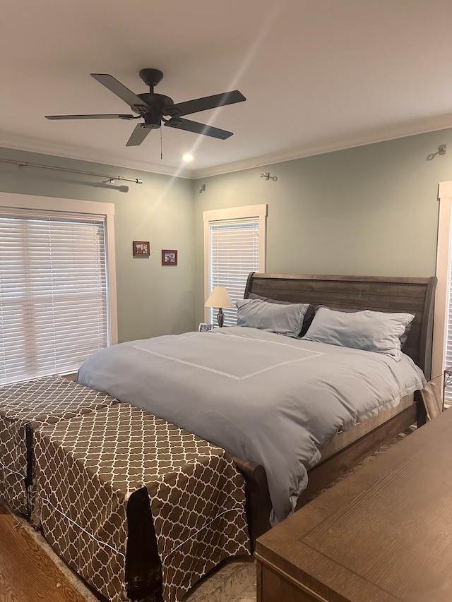 bedroom with ceiling fan, wood-type flooring, and ornamental molding