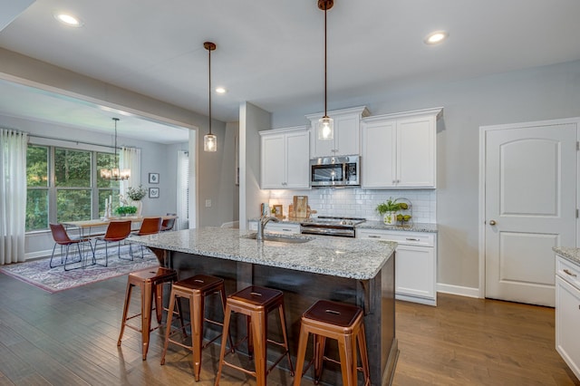 kitchen featuring white cabinets, sink, an island with sink, and stainless steel appliances