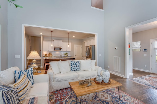 living room with dark hardwood / wood-style floors and sink