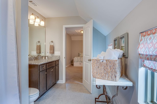 bathroom featuring vanity, vaulted ceiling, and toilet