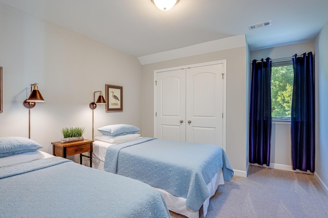 bedroom featuring light colored carpet and a closet