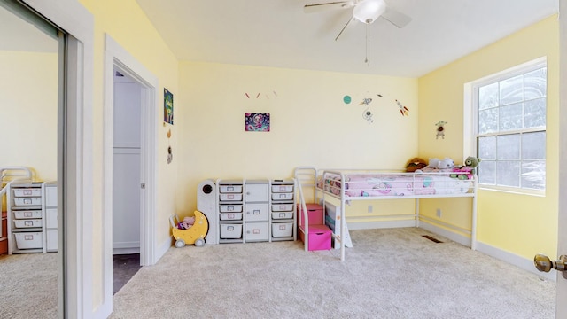 bedroom with ceiling fan, light colored carpet, and a closet