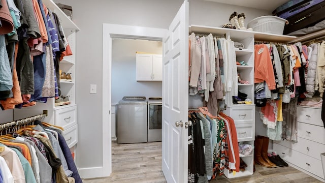 walk in closet featuring washer and dryer and light hardwood / wood-style floors