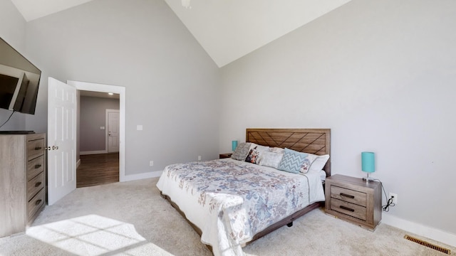 carpeted bedroom with high vaulted ceiling