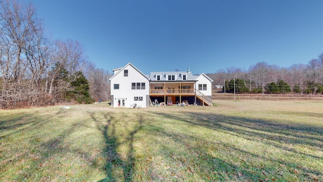 rear view of property with a wooden deck and a lawn