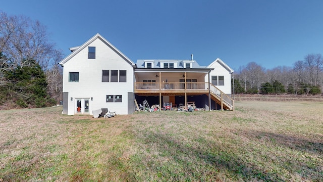 rear view of house with a deck, ceiling fan, and a lawn