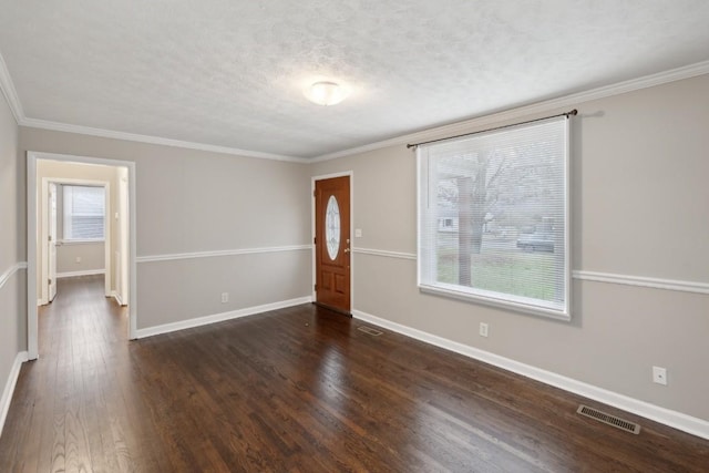 spare room featuring a textured ceiling, dark hardwood / wood-style floors, and ornamental molding