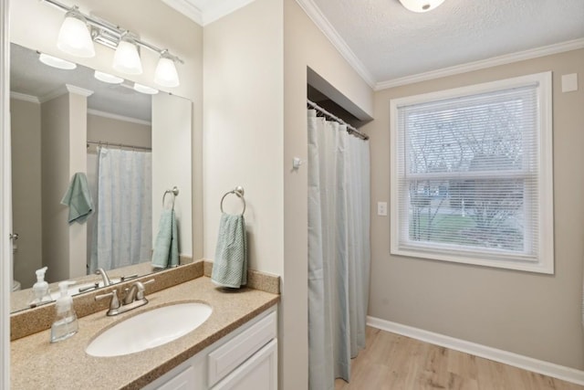 bathroom with vanity, wood-type flooring, a textured ceiling, and ornamental molding