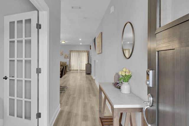 hallway with light hardwood / wood-style floors