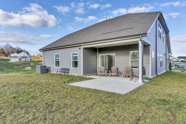 rear view of property with a yard, a patio, and central air condition unit