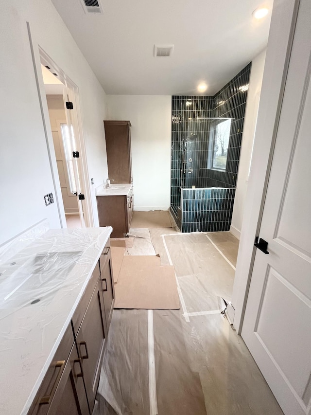 bathroom featuring vanity and a shower with shower door