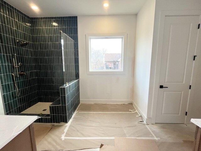 bathroom with vanity and tiled shower