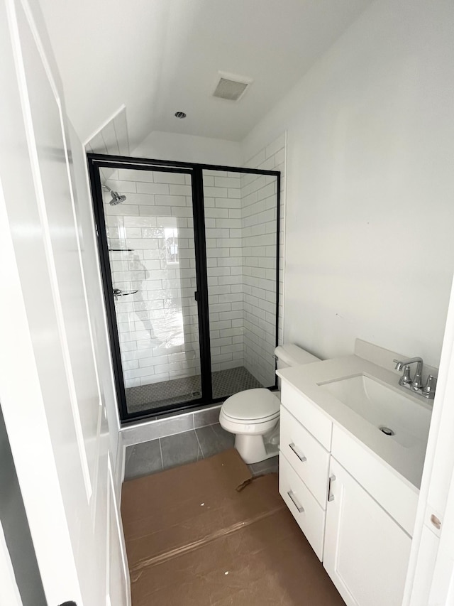 bathroom featuring tile patterned floors, vanity, toilet, and a shower with shower door