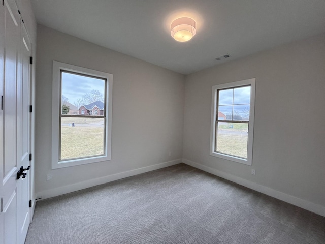 carpeted empty room with baseboards