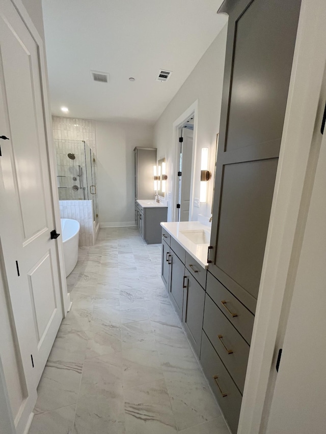 bathroom featuring marble finish floor, a shower stall, visible vents, and two vanities