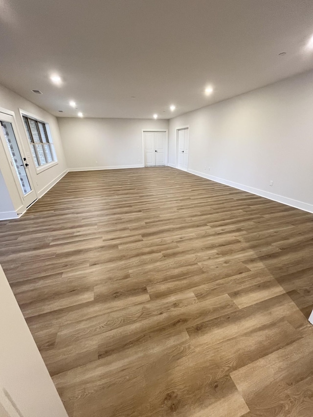 interior space with baseboards, wood finished floors, and recessed lighting