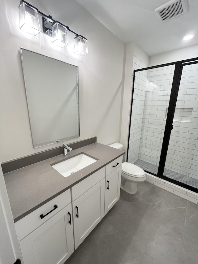 bathroom featuring toilet, vanity, a shower stall, and visible vents