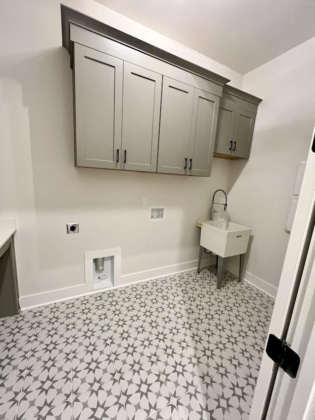 laundry area featuring hookup for a washing machine, hookup for an electric dryer, a sink, baseboards, and cabinet space