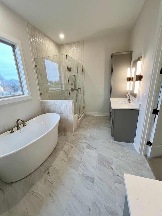 bathroom with baseboards, marble finish floor, vanity, a freestanding tub, and a shower stall