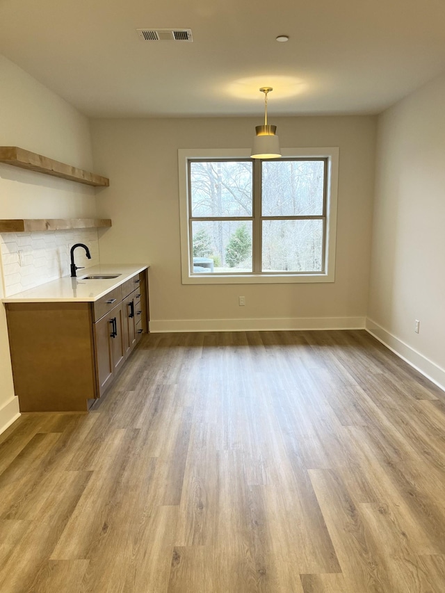 bar featuring wood finished floors, a sink, and visible vents