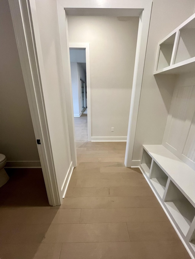 mudroom featuring baseboards and wood finished floors