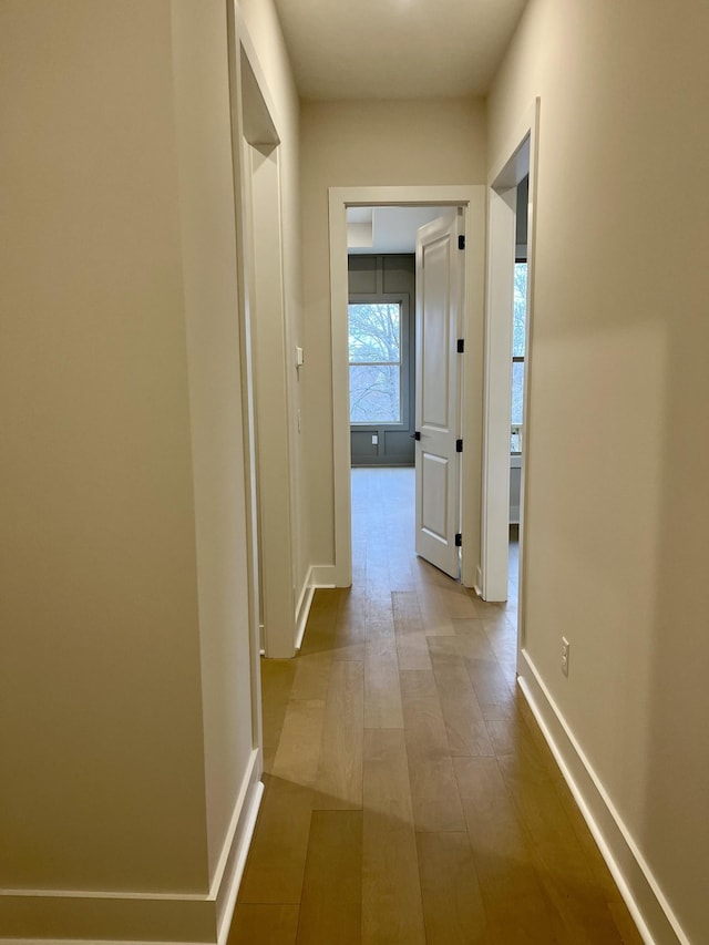 corridor with wood finished floors and baseboards