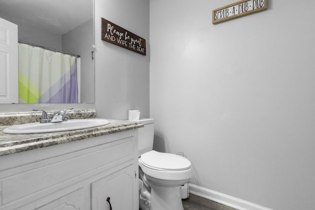 bathroom with hardwood / wood-style floors, vanity, and toilet