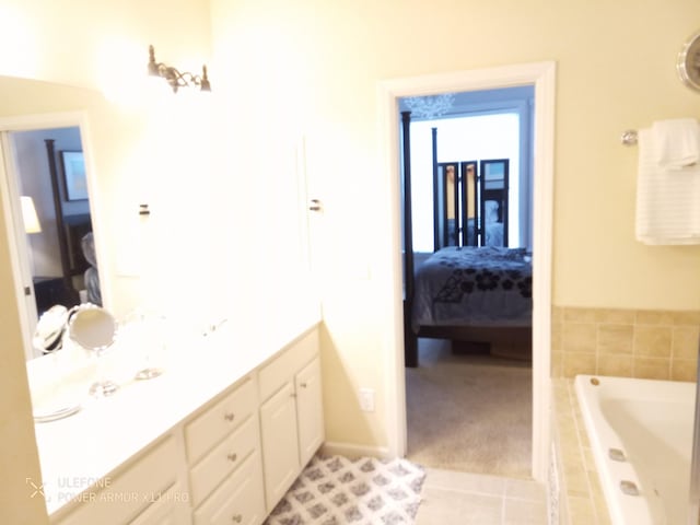 bathroom featuring vanity, tiled bath, and tile patterned floors