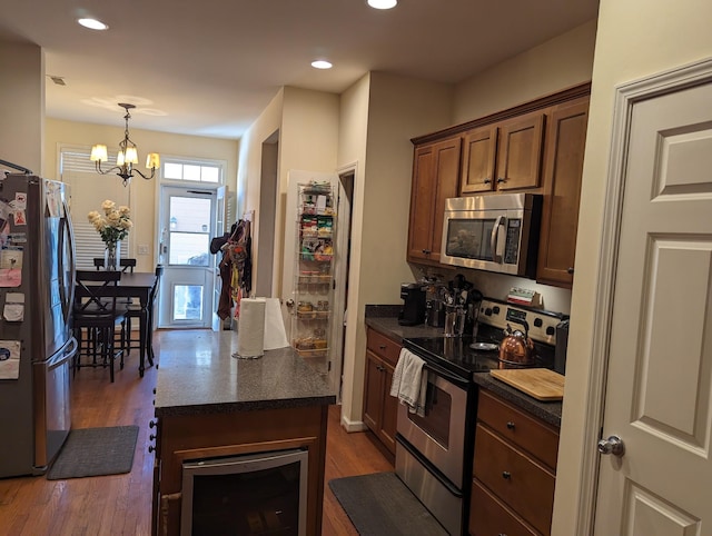 kitchen with pendant lighting, wine cooler, dark hardwood / wood-style floors, stainless steel appliances, and a chandelier