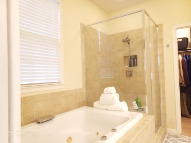 bathroom featuring shower with separate bathtub