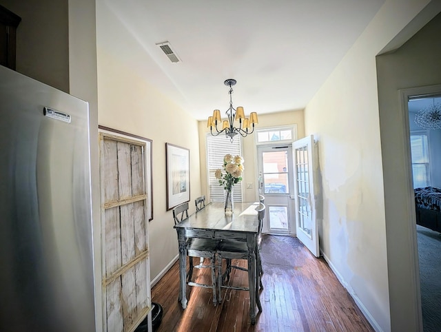 dining area featuring dark wood-type flooring and a chandelier