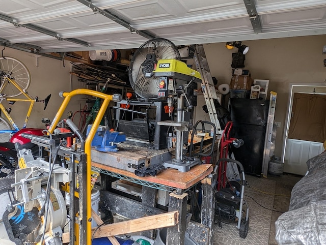 garage featuring black refrigerator and a workshop area