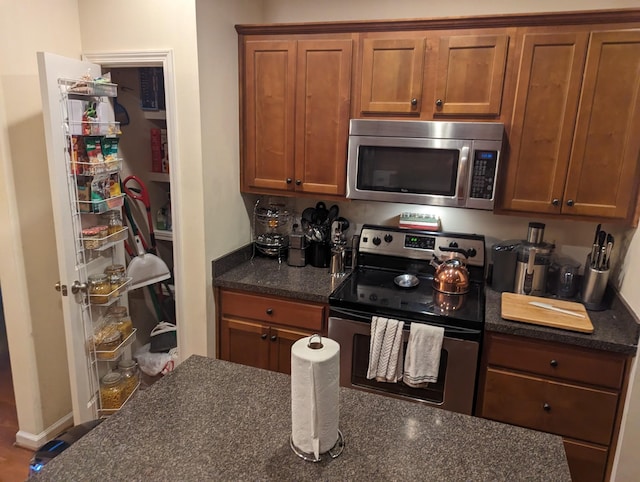 kitchen with dark stone countertops and appliances with stainless steel finishes