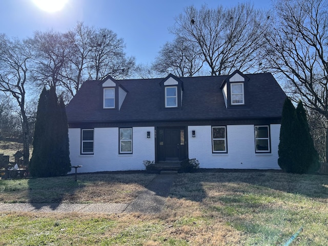 cape cod house featuring a front lawn