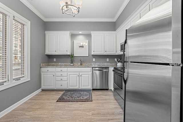 kitchen with light stone countertops, appliances with stainless steel finishes, ornamental molding, sink, and white cabinets