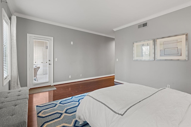 bedroom featuring dark hardwood / wood-style flooring, ornamental molding, and multiple windows