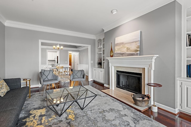 living room with built in shelves, ornamental molding, and dark wood-type flooring