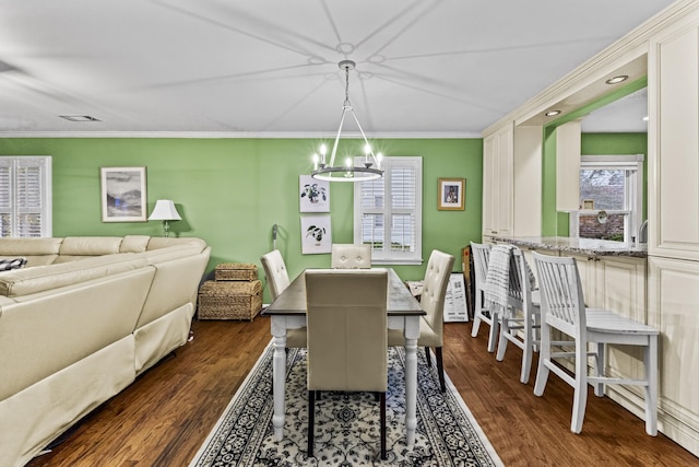 dining room featuring crown molding, dark hardwood / wood-style flooring, and a notable chandelier