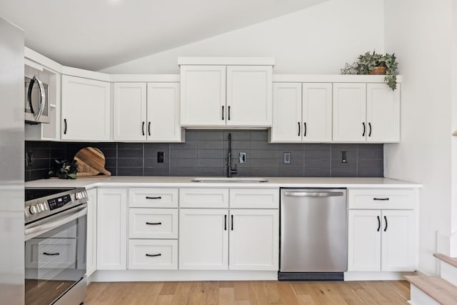 kitchen featuring sink, stainless steel appliances, decorative backsplash, and white cabinetry