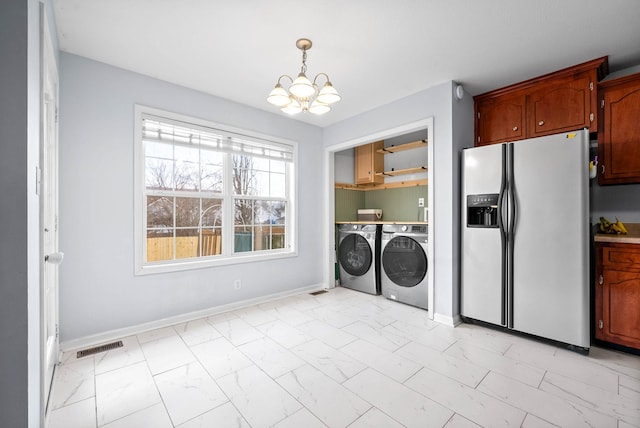 washroom with washer and dryer and a chandelier