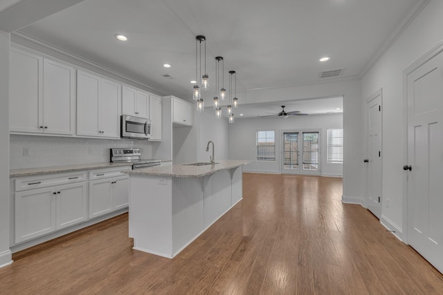 kitchen featuring white cabinetry, a center island with sink, hanging light fixtures, and appliances with stainless steel finishes