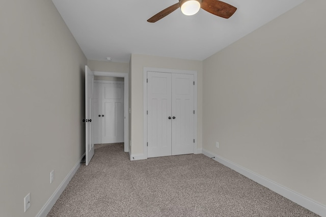 unfurnished bedroom featuring a closet, light colored carpet, and ceiling fan