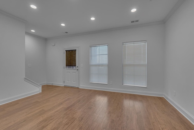 unfurnished room featuring light wood-type flooring and ornamental molding